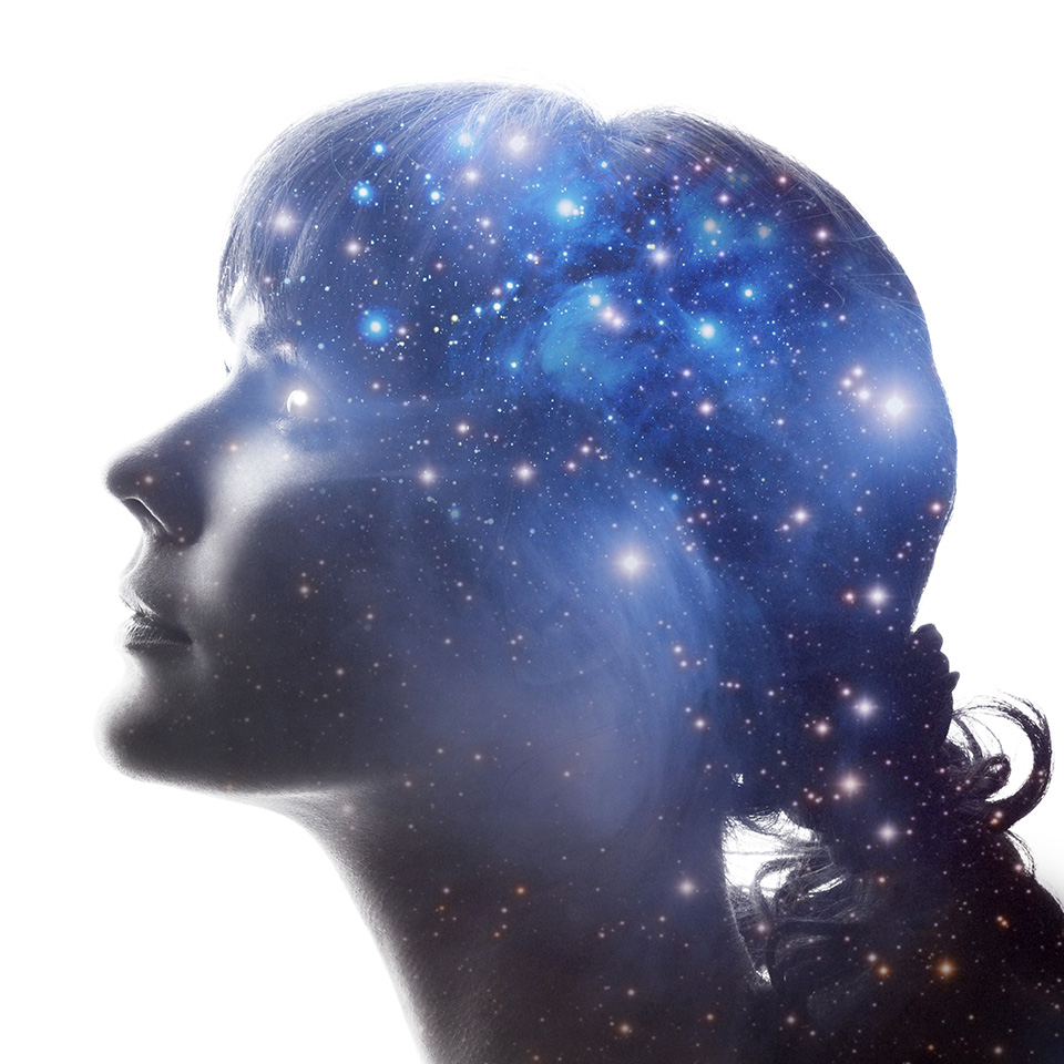A double exposure of the profile of a woman and the cosmos