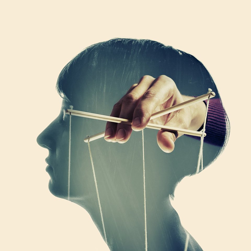 Double exposure of a head with hand inside holding puppeteer controller strings