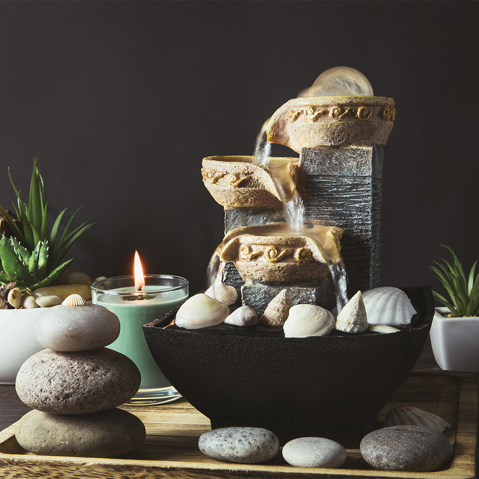 Pebbles, plants, and fountain arranged using feng shui principles